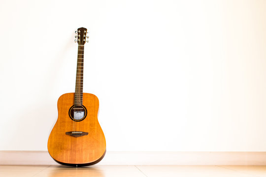 Acoustic guitar standing on floor