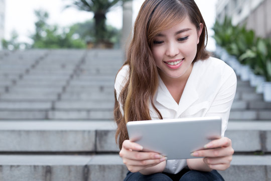 Asian female student using tablet in campus