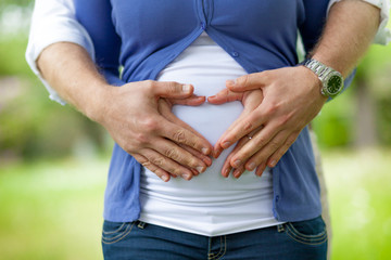 couple pregnant forming heart