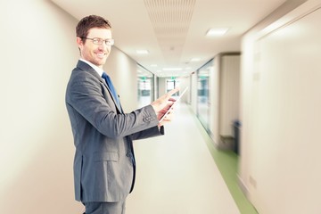 Composite image of businessman using his tablet pc 