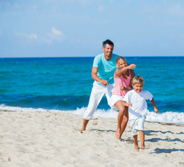 Kids and father playing on the beach.