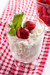 cottage cheese in a glass glass with strawberries and mint
