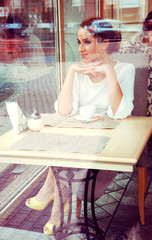 Beautiful elegant blonde sitting in a cafe drinking tea.View thr