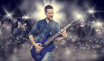 handsome young man playing electric guitar