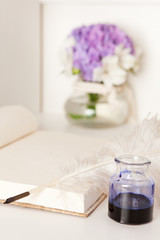 Offenes Buch mit eleganter Füllfeder und Tintenfass