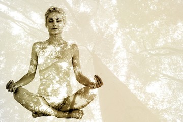 Toned young woman sitting in lotus pose with eyes closed