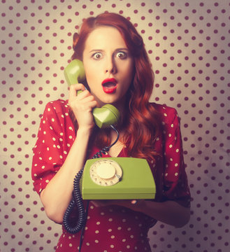 Portrait of a redhead girl with green dial phone
