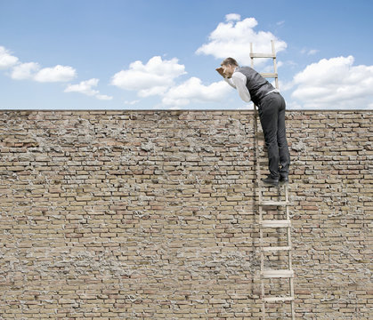 Businessman is Looking Over Brick Wall on Ladder for New Opportunity-Job Search Concept