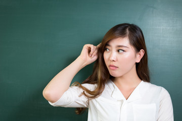 asian beautiful woman thinking in front of blackboard