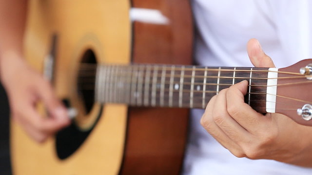 Close up of hand playing acoustic guitar 