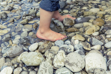 child barefoot river gravel