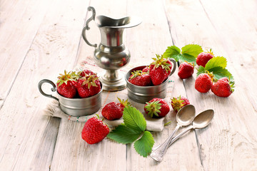 Strawberry in metal cup on white background