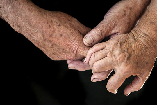 Wrinkled hands of two people