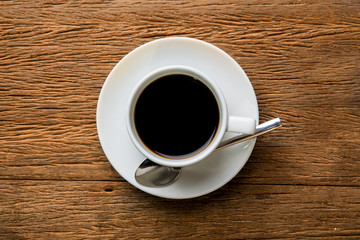 Hot coffee with spoon on table.