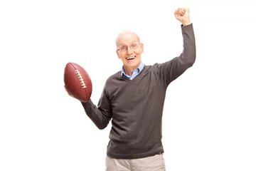 Fotobehang Joyful senior man holding an American football © Ljupco Smokovski