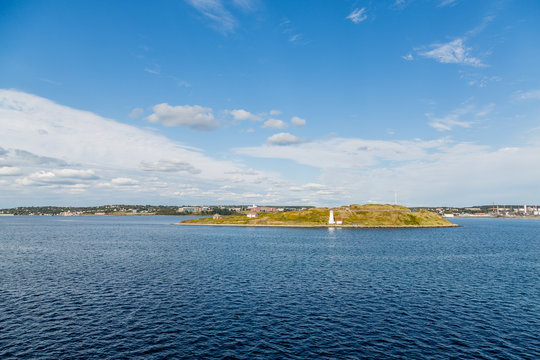 White Lighthouse Across Blue Bay