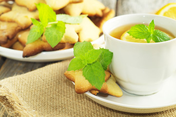 Cup of tea with slice of lemon and home made cookies. Selective focus