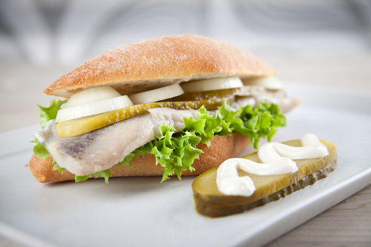 Matjesbrötchen mit Salat, sauren Gurken und Zwiebeln