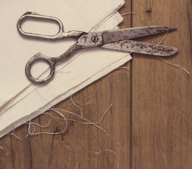 Old sewing scissors on the wooden background