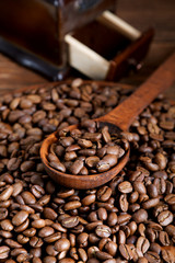 grinder and coffee beans with a wooden spoon