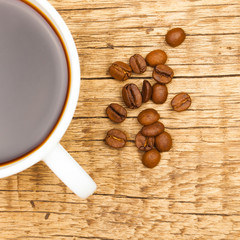 Expresso and coffee beans on old wooden table