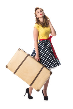 Mädchen im Rockabilly Style trägt einen Koffer