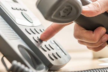 Closeup of male telemarketing salesperson holding a telephone re - obrazy, fototapety, plakaty