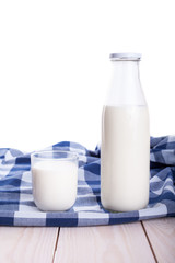 Milk cup and bottle on wooden table