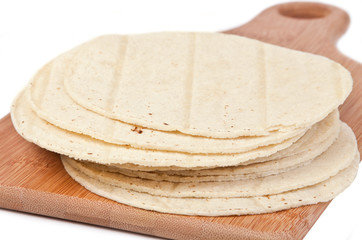 Corn Tortillas – A stack of corn tortillas on a wooden cutting board.