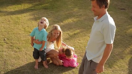 father with hula hoop being watched by family - Powered by Adobe