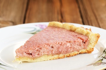 Piece of homemade strawberry tart on old wooden table