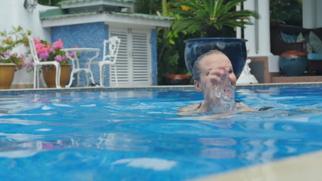 Young smiling woman in the swimming pool.