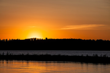 Fototapeta premium Sunset behind lake and forest
