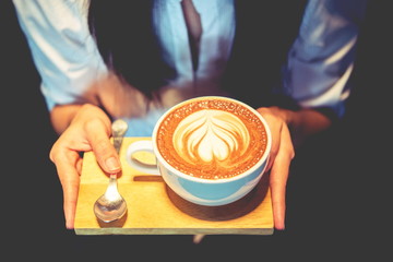 woman holding coffee mocha hot on wooden table