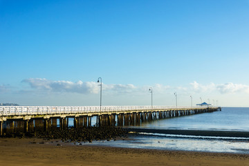 Shorncliffe Pier in early morning sun under a blue sky