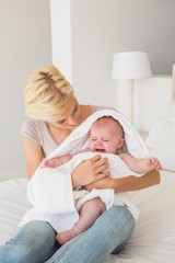 Beautiful mother with her baby girl wrapped up in a towel 