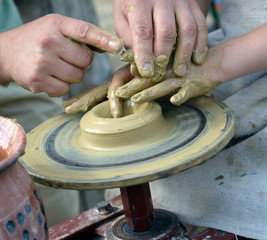 Hands working on pottery wheel