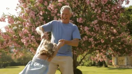 grandfather and granddaughter playing in park