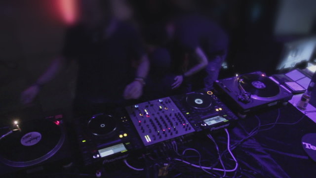 Top view of DJ mixing, playing music on professional sound deck