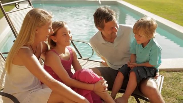 family group sitting by pool