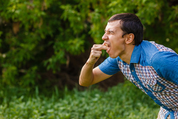 Man on the street nausea vomiting on a green background  leaves 