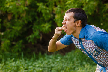 Fototapeta premium Man on the street nausea vomiting on a green background leaves 