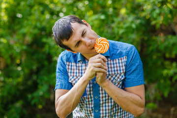 The man in the street holding a lollipop on a green background l