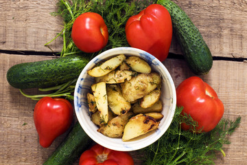 homemade food, fried potatoes, tomatoes, cucumbers and fennel on wooden table