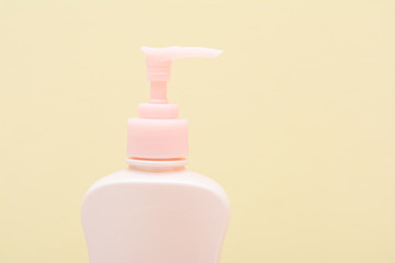 pink plastic bottles pump on yellow background