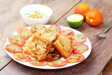 Fried bread with minced pork spread on wood table.