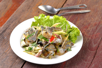 spicy mango salad with blue crab on wood table.