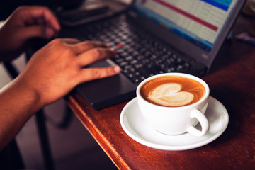 Businessman is working with laptop, holding a mobile phone