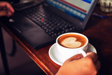 Businessman is working with laptop, holding a mobile phone