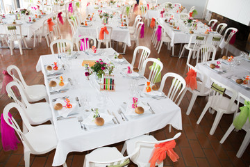 Table setting for an wedding reception in orange, pink and yellow color